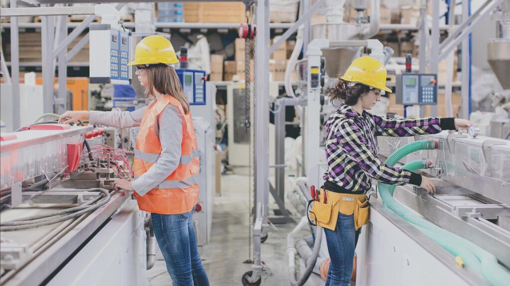 Two factory workers in plastic production facility.