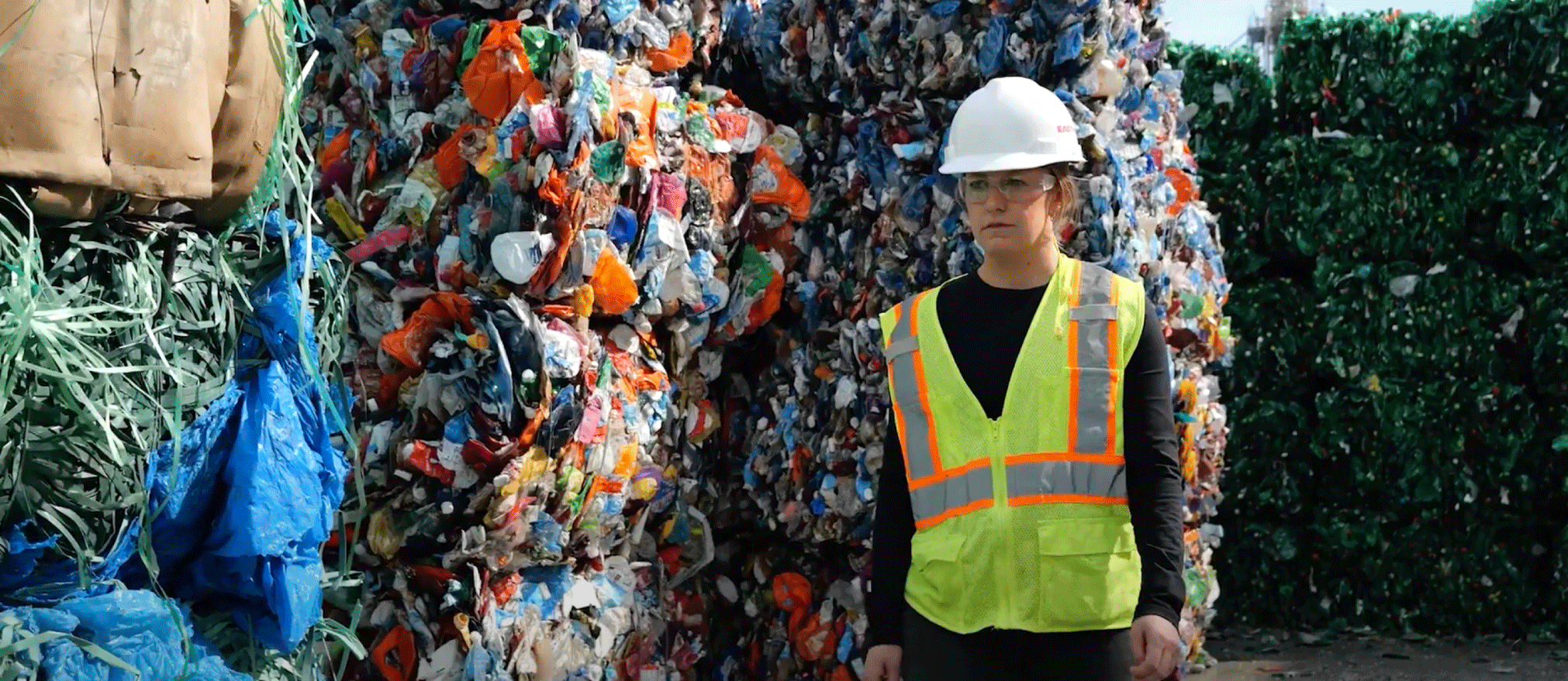 Aerial view of wind turbines made using plastic, backlit by evening light.